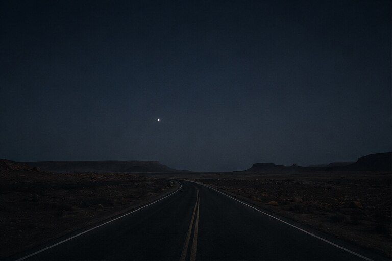 Route traversant le désert sous un ciel bleu nuit